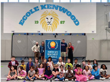 group of students sitting around banner
